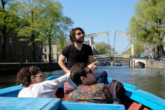 Rondvaart met Rederij Lampedusa. Op de achtergrond de Walter Suskindbrug. Tommy vertelt zijn eigen levensverhaal maar ook het levensverhaal van Amsterdam. Rondvaart door de Amsterdamse grachten met Rederij Lampedusa. Vluchtelingen vertellen tijdens de boottocht hun verhaal.