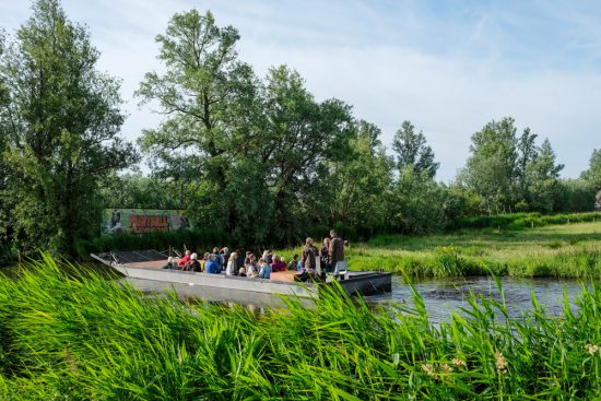 Wandelen over water in Natuurpark Guisveld in Zaandijk, Zaanstad, Nederland. Tijdens het Wandelen over Water event kun je ook een boottocht maken