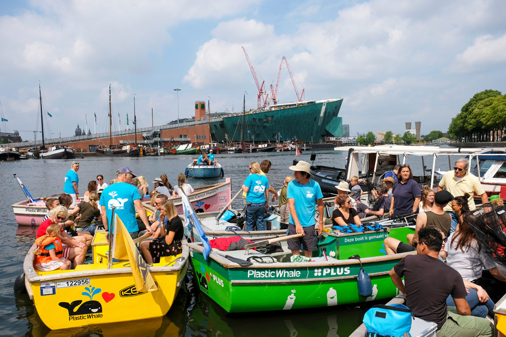 De sloepen van Plastic Whale zijn gemaakt van PET flessen opgevist uit de Amsterdamse grachten. Plastic Whale vissen in de Amsterdamse grachten , de dag na Pride Amsterdam