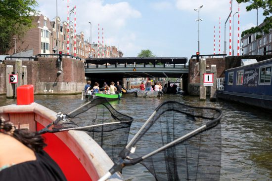 Even een rustmomentje als we wat sneller door Amsterdam varen. Plastic Whale vissen in de Amsterdamse grachten , de dag na Pride Amsterdam