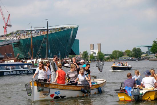 Visnetjes in de aanslag, klaar voor enkele uren plastic vissen. Plastic Whale vissen in de Amsterdamse grachten , de dag na Pride Amsterdam