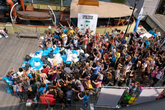 Een Plastic Whale groepsfoto met de afvalbuit van de dag. Plastic Whale vissen in de Amsterdamse grachten , de dag na Pride Amsterdam