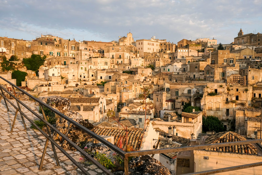 De vroege ochtendzon kleurt de sassi warmgeel. Rondreis Basilicata, Italie, langs Matera en ankele andere stadajes in de Kleine Dolomieten van Lucarna